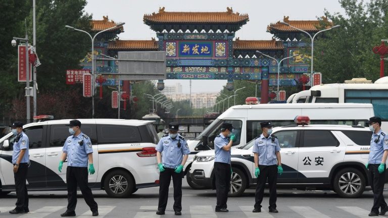 Policiais chineses bloqueiam entrada do mercado de Xinfadi em Pequim, em 13 de junho de 2020 - AFP