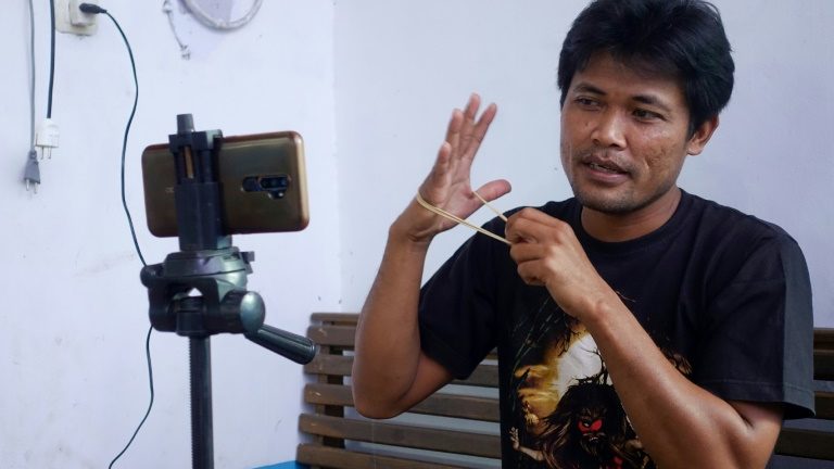 O YouTuber indonésio Siswanto gravando um de seus vídeos em casa, na comunidade agrícola de Banyuwangi - AFP