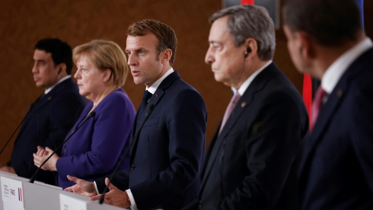 O presidente francês Emmanuel Macron (centro), participa de coletiva de imprensa ao lado do primeiro-ministro italiano, Mario Draghi, e da chanceler alemã Angela Merkel durante a Conferência Internacional sobre a Líbia em Paris, em novembro de 2021 - POOL/AFP