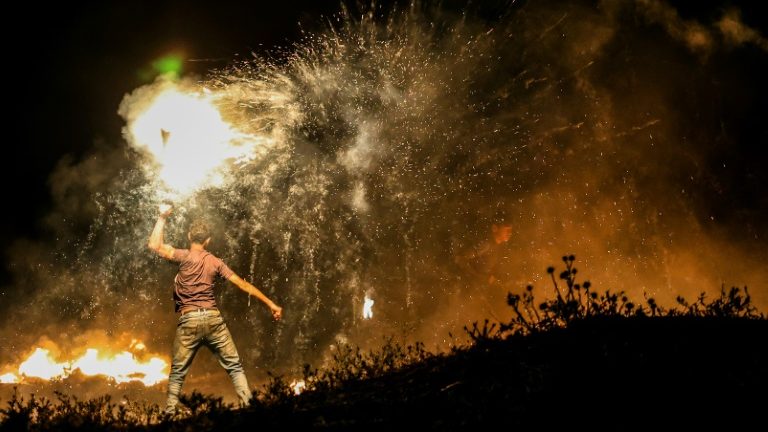Um manifestante na Faixa de Gaza acende um dispositivo incendiário durante os confrontos de maio - AFP/Arquivos