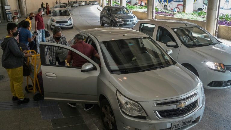 Pessoas entram em um carro solicitado por meio de um aplicativo no Aeroporto de Congonhas em São Paulo, Brasil, em 10 de fevereiro de 2022 - AFP