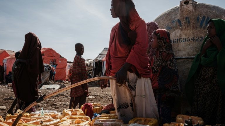 Mulher se abastece de água em um campo de deslocados na Somália, em 13 de fevereiro de 2022 - AFP