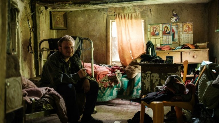 Homem visia a casa da mãe, sem energia elétrica, água ou serviço de telefone, em Lysychansk, Ucrânia, em 15 de maio de 2022 - AFP