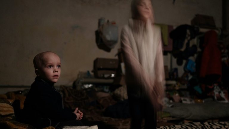 Sasha (E), de quatrno anos, e a irmã Ksenia, de oito, em um refúgio de Lysychansk, na Ucrânia - AFP
